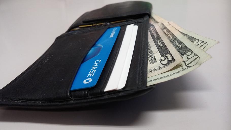 otevřená pánská peněženka s bankovkami a kreditkou